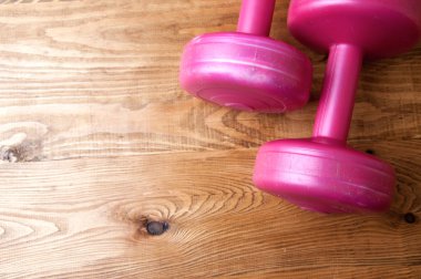 Ahşap bir masa üzerinde iki pembe halter