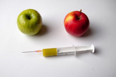 Şırınga ile yeşil ve Kırmızı elma. GDO