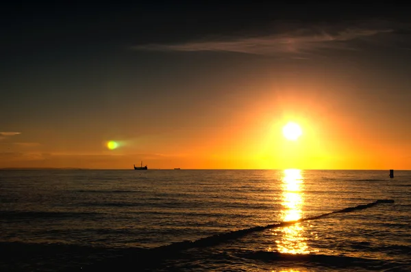 O mar e a praia ao pôr do sol — Fotografia de Stock