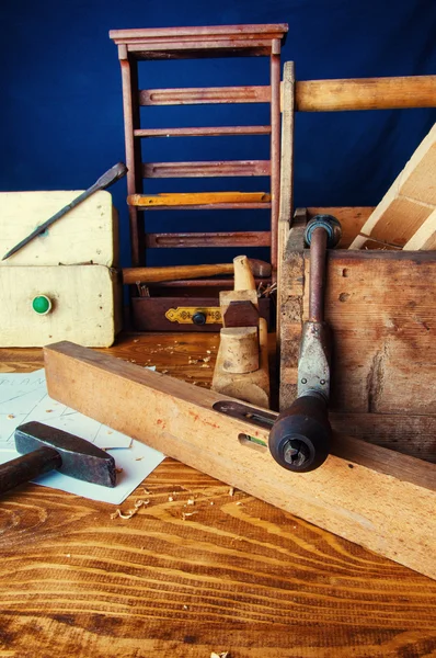 Apparatuur timmerman op een houten bureau met plannen Stockafbeelding