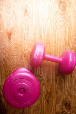 Ahşap bir masa üzerinde iki pembe halter