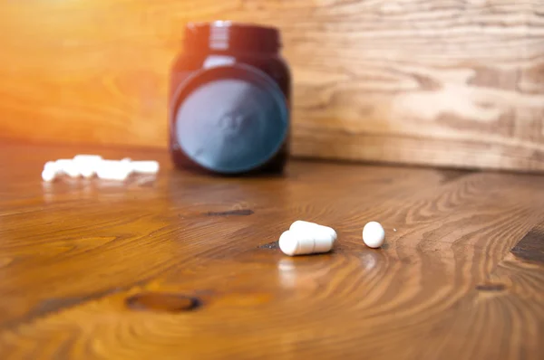 Comprimidos de creatina em uma mesa de madeira — Fotografia de Stock