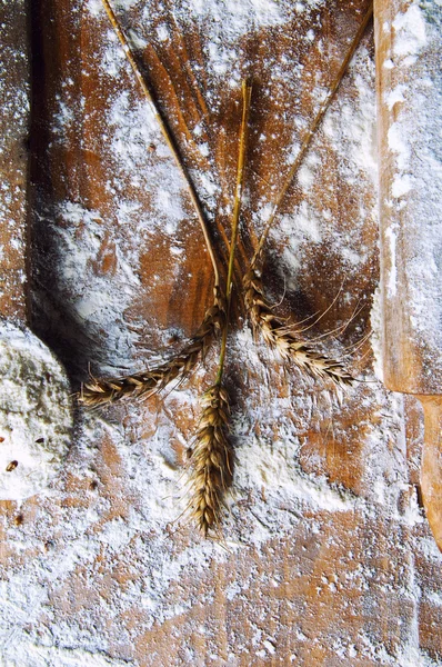 Farina di rullo e un cucchiaio di legno e spighe di grano — Foto Stock