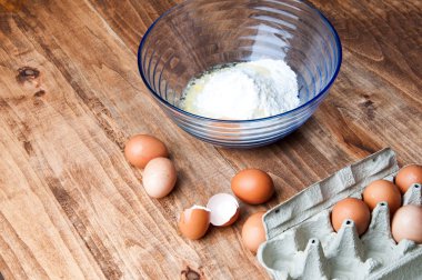 Yumurta ve un ahşap bir masa üzerinde görüntü.