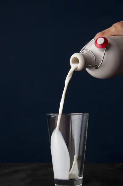 Milch in ein Glas gießen — Stockfoto