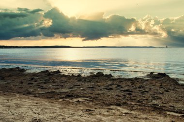 Deniz, plaj ve bulutların arkasında ışık