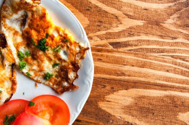 ahşap bir masa üzerinde domates ile kızarmış yumurta