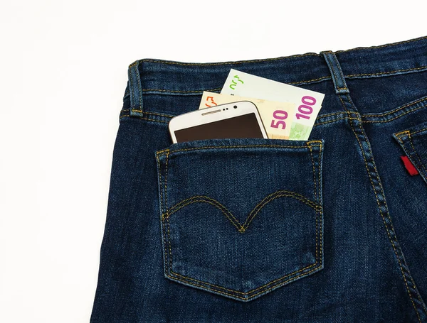 Nella tasca dei pantaloni di un denim blu c'è uno smartphone e una banconota — Foto Stock