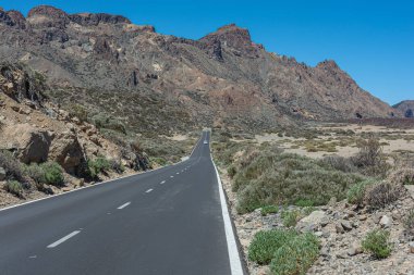 Dağ manzarası. Dağın eteğindeki dağlık bir bölgede yol. Stok fotoğrafı