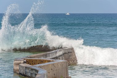 Deniz dalgası beton bir dalgaya çarpar. Stok Fotoğrafı