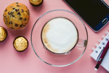 Kapuçino çöl ve masanın üstünde a telefon ile