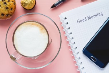 kahve ve defter ve pembe bir tablo bir telefonda