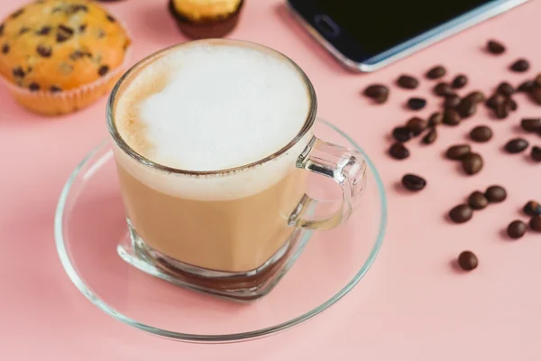Secangkir kopi dengan telepon dan kacang di atas meja merah muda — Stok Foto