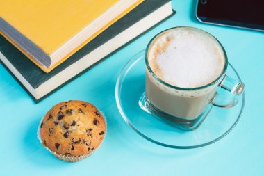 Kapuçino fincan kek ve kitap bir tablo ile 