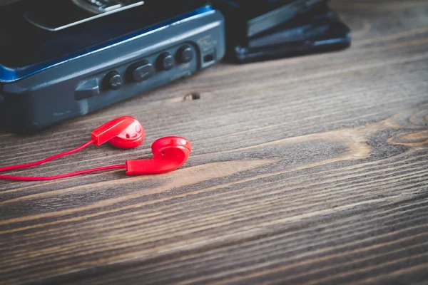 古いカセット プレーヤーとテーブルの上の赤いヘッドフォン — ストック写真