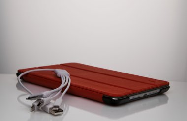 Kırmızı kaplı ve bağlantı telleri olan tablet bilgisayar.