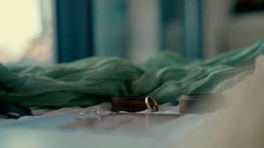 Sinema yavaş çekim videosu romantik bir anı yakalar, ikinci bir altın yüzük yumuşak bir yüzeye uzanmış başka bir yüzüğün yanına nazikçe düşer..