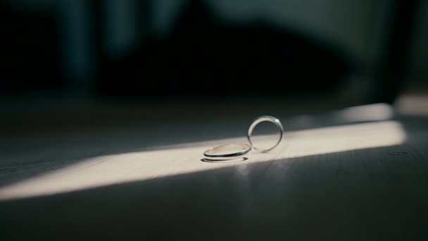 Two wedding rings in slow motion one lying still yje other spinning nearby. Symbolic concept of love marriage connection and relationship. Two wedding rings in slow motion one lying still yje other spinning nearby. Symbolic concept of love marriage connection and relationship.