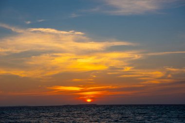 İnanılmaz bir gün batımı. Sakin, sakin, palmiye ağaçlı deniz dalgaları. Güzel Panorama, Tropikal ada sahili egzotik sahil manzarası. Yaz tatili, harika bir tatil. Rahatla cennet, Maldivler..