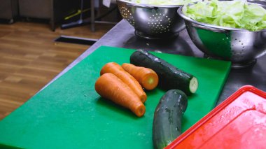 Yeşil tepside pişmeye hazır havuçlar ve salatalıklar..