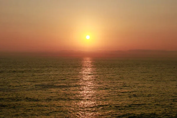 Sunset on the beach, the sun sets into the sea.