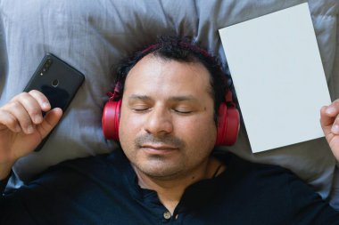 Latin adam yatakta müzik dinlerken rahatladı.