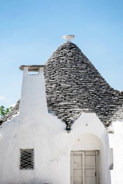 Alberobello, Puglia, Brindisi, Italy - july 19, 2017: View of the Famous village with typical dry stone Trulli houses and conical roof. Trulli picturesque street in the old town. Cone-roofed houses