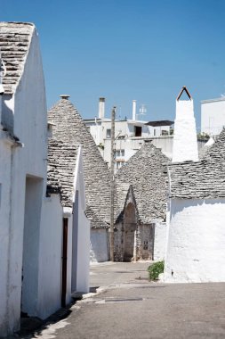 Alberobello, Puglia, Brindisi, Italy - july 19, 2017: View of the Famous village with typical dry stone Trulli houses and conical roof. Trulli picturesque street in the old town. Cone-roofed houses