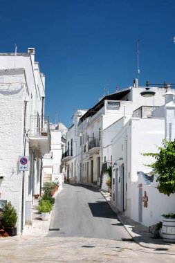 Alberobello, Puglia, Brindisi, Italy - july 19, 2017: View of the Famous village with typical dry stone Trulli houses and conical roof. Trulli picturesque street in the old town. Cone-roofed houses