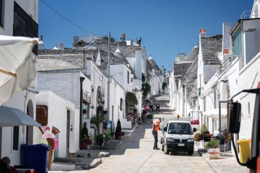 Alberobello, Puglia, Brindisi, Italy - july 19, 2017: View of the Famous village with typical dry stone Trulli houses and conical roof. Trulli picturesque street in the old town. Cone-roofed houses