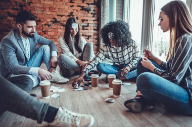 Kahve molası sırasında alnında çıkartmayla daireler çizen neşeli meslektaşlar.