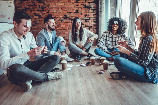 Gençler oyunu oynar. Alnında çıkartmalar var. Mutlu anları hatırla. En iyi arkadaşlar iyi tatiller. Gülümseyen arkadaşlar.