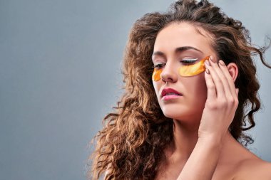 Kırışıklıklar ve siyah halkalar yüzünden göz altı yamaları olan genç bir kadının yakın çekimi. Gey geçmişinde izole edilmiş. Boşluğu kopyala