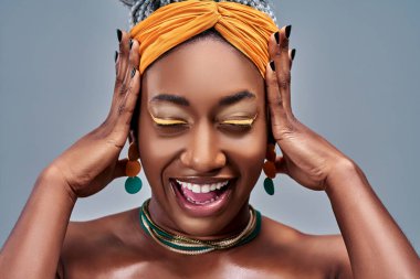 Mutlu ve güzel bir kadının portresini yakından çek. İnançsız ellerle, izole edilmiş gri arka planda şaşırmış..