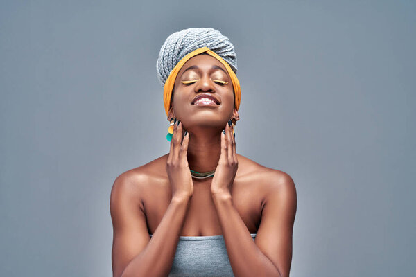 Beautiful young Afro-American woman touching her face and keeping eyes closed while Isolated on gray background. Copy space
