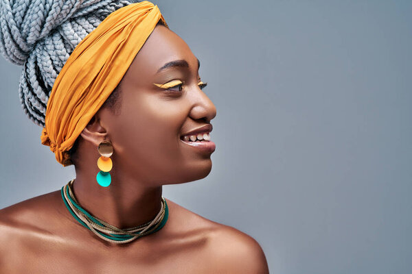 Side view portrait of beautiful attractive African American woman over grey studio background. Copy Space.