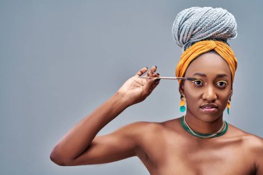 Maskara tutan güzel Afro Amerikalı kızın portresi ve gri bir arka planda kameraya bakması. Boşluğu kopyala