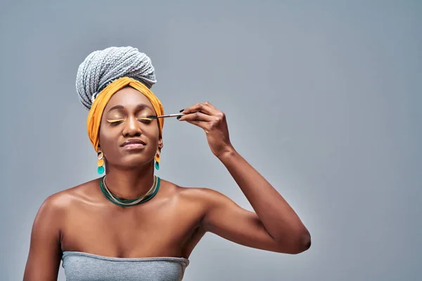 美丽惊人的非洲裔美国妇女模型使用新的额外长睫毛应用 被灰色背景隔离 复制空间 — 图库照片