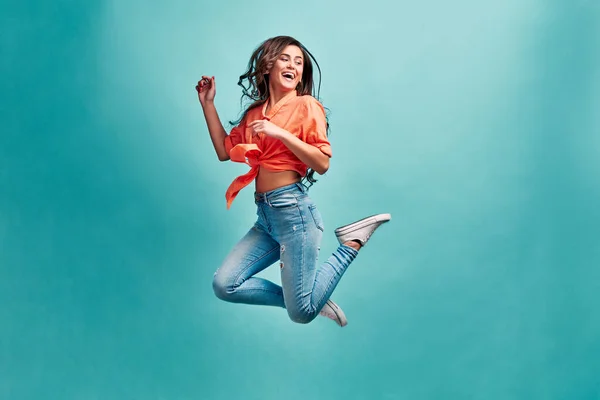 Foto Uma Menina Bonita Saltando Fundo Azul Com Felicidade Olhando — Fotografia de Stock
