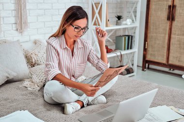 Gözlüklü güzel bayan sabahın erken saatlerinde yataktan çalışıyor..