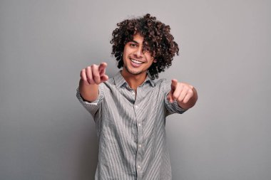 Doğulu kıvırcık çocuğun stüdyo görüntüsü iki elinle de sana dokunuyor..