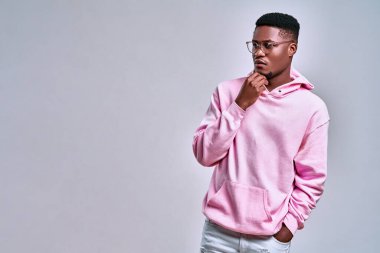 Pembe kapüşonlu, şık giyinmiş bir adamın portresi. Reklam için boş alana ciddi ciddi bakmayan ve düşünceli bir adam. Mekan, moda, kıyafet kopyalama..