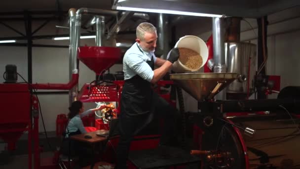 烘焙咖啡的过程 企业家将生咖啡豆倒入现代烘焙机 — 图库视频影像