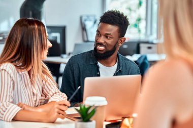 Profesyoneller yeni bir proje yaratıyor. Toplantı masasında tablet kullanan çok ırklı iş adamları. Çok ırklı takım konsepti. Seçici odak