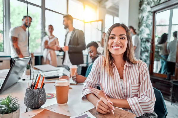 Smilende Kvindelig Medarbejder Sidder Coworking Plads Arbejder Projektet Forside - Stock-foto