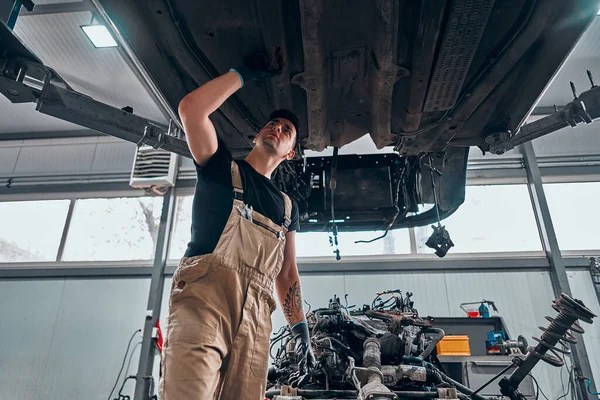 Mecánico Examinando Debajo Del Coche Garaje Reparación Vista Ángulo Bajo —  Fotos de Stock