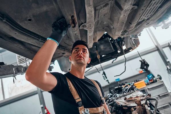 Mecánico Examinando Debajo Del Coche Garaje Reparación Vista Ángulo Bajo —  Fotos de Stock