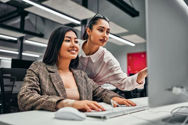2人の美しい成功したビジネス女性はコンピュータで一緒に働く チームワークだ ビジネスの女性は コンピュータ画面上のプロジェクトを示しています — ストック写真