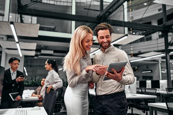 Two Beautiful Successful Smiling Business People Standing Looking Tablet Screen — Fotografia de Stock