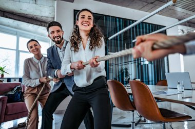 İş ortaklarıyla halat çekme oyunu oynayarak rekabetçi bir avantaj elde eden genç iş adamlarının görüntüsü. Ofis ayarlama. Takım oluşturma kavramı